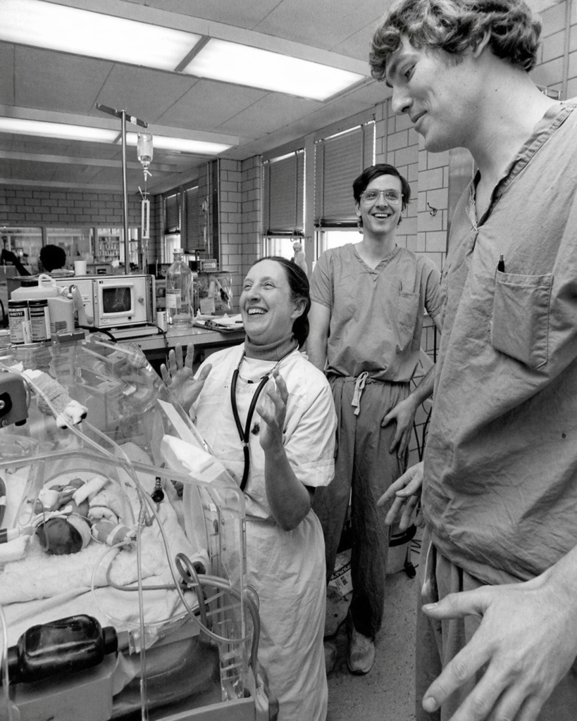 Fotografía histórica de Mildred Stahlman con personal médico junto a una incubadora neonatal.