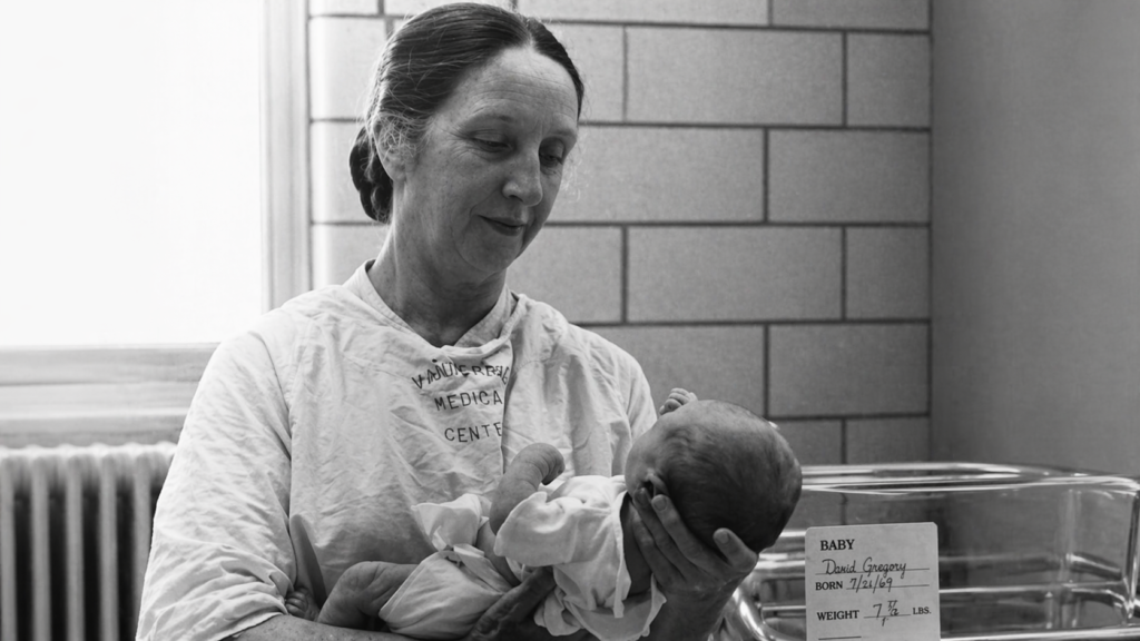 Fotografía histórica de Mildred Stahlman sosteniendo a un recién nacido en un entorno hospitalario.