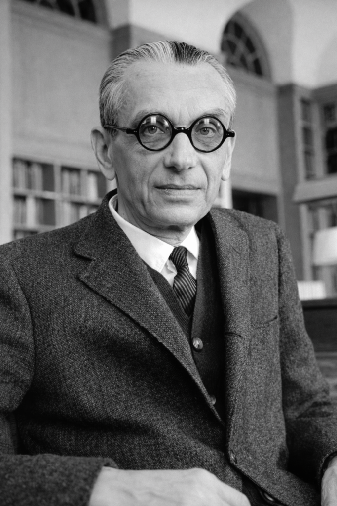 Retrato en blanco y negro de un hombre mayor con gafas redondas y traje, relacionado con la vida y obra de Kurt Gödel.