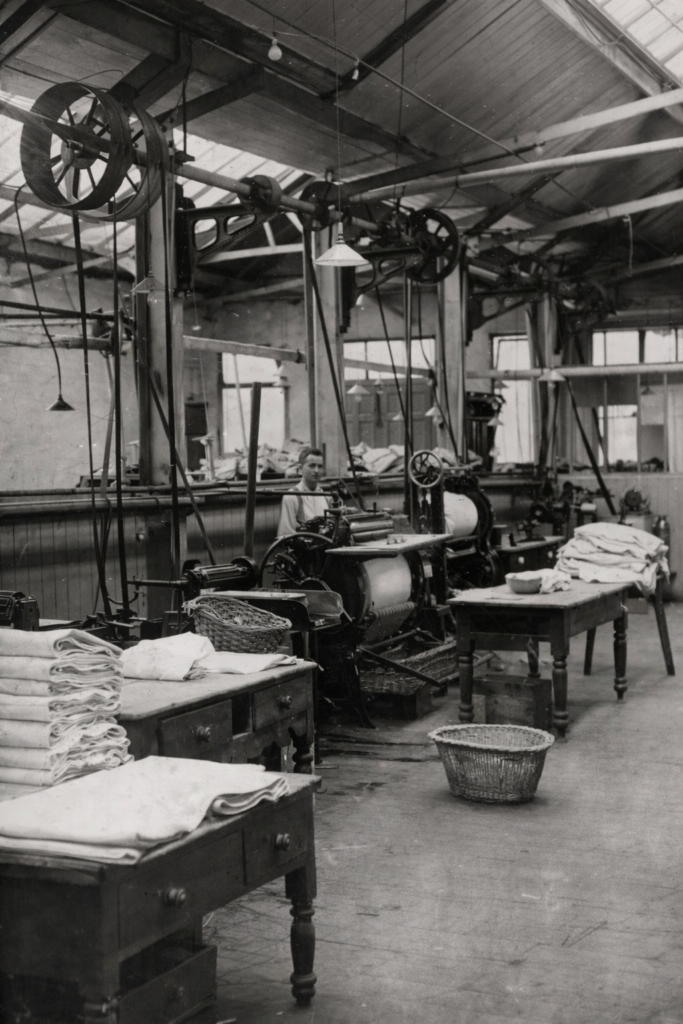 Fotografía antigua de una lavandería industrial, relacionada con la historia de la limpieza en seco y el legado de Thomas L. Jennings.